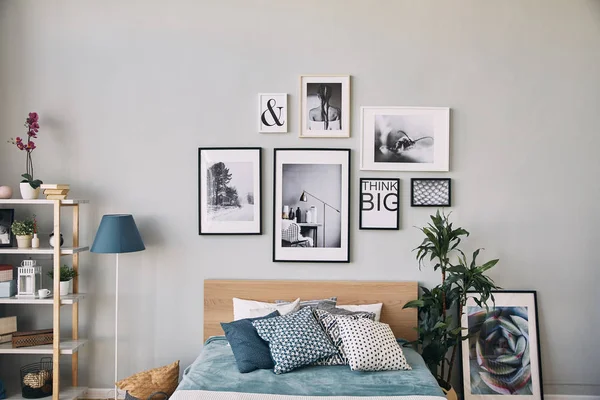 Photos of different sizes in a frame hanging over the bed . Modern bedroom interior. — Stock Photo, Image