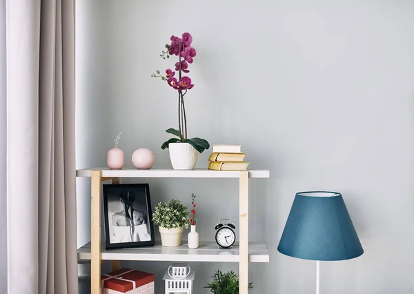 Lilac flower is in a pot on the shelf. Modern interior. — Stock Photo, Image