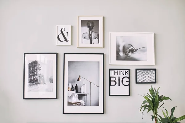 Different size framed photos hanging on the gray wall. — Stock Photo, Image
