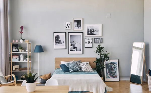 Photos of different sizes in a frame hanging over the bed . Modern bedroom interior. — Stock Photo, Image