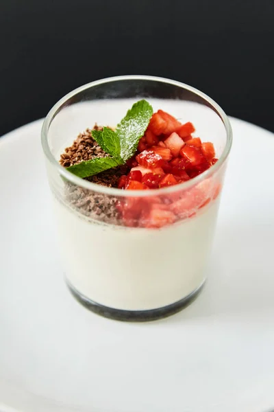 Helado con chocolate rallado y fresas. Plato sobre fondo negro . — Foto de Stock