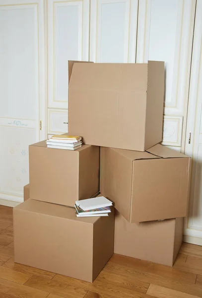 moving boxes with a stack of books. cardboard box. stack of boxes