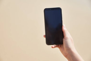Hareket eden telefon içinde plaj ve okyanus zemin üzerine el