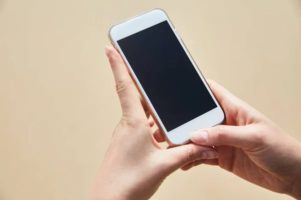 Mobile phone in female hand on the background of the beach and ocean — Stock Photo, Image