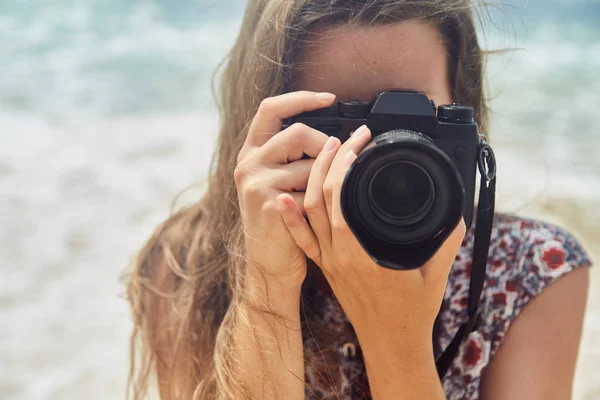 夏のビーチにカメラで写真を撮る若い女の子 — ストック写真