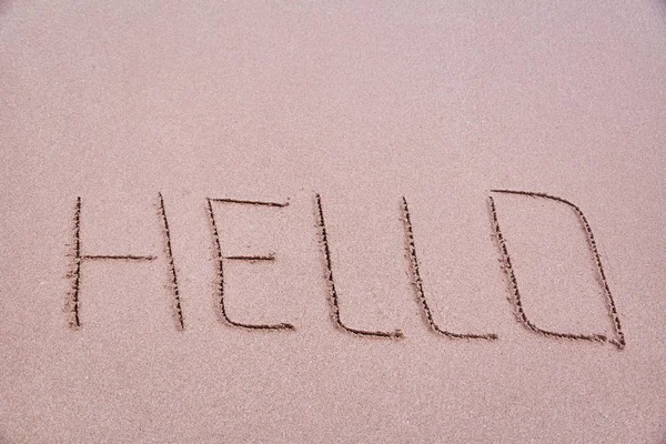 คําจารึกบนทราย "สวัสดี" เขียนเป็นภาษาอังกฤษ — ภาพถ่ายสต็อก