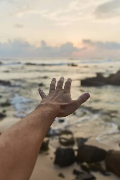 Le gars tend la main vers les nuages. Le gars tire sa main vers la mer — Photo