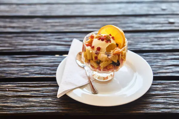 Salade de fruits frais dans une assiette sur un fond en bois — Photo