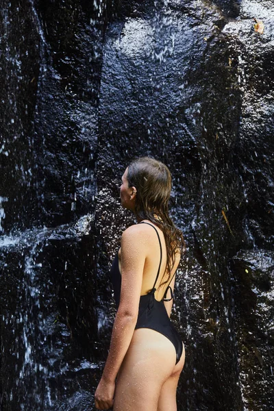 Una joven está bajo una cascada —  Fotos de Stock
