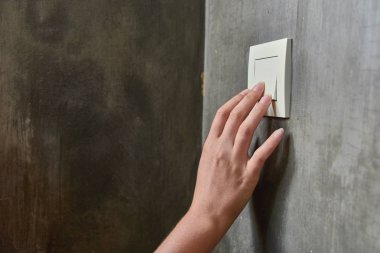 Kadın eli, ışığı söndürmek için, düğme, ön görünüm