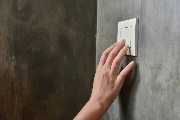 Female hand, to turn off the light, switch, front view — Stock Photo, Image