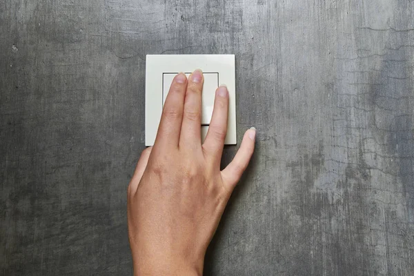 Vrouwelijke hand, om het licht uit te doen, schakelaar, vooraanzicht — Stockfoto