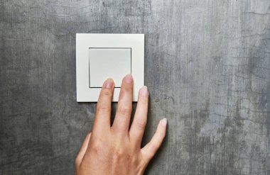 Kadın eli, ışığı söndürmek için, düğme, ön görünüm