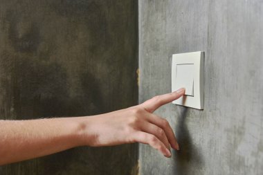 Kadın eli, ışığı söndürmek için, düğme, ön görünüm