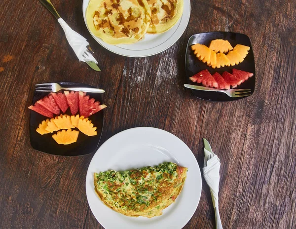 Omelete e um prato de frutas (melancia e manga) é um pequeno-almoço tradicional na Indonésia . — Fotografia de Stock