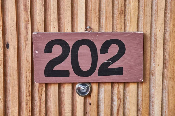 Firma sulla porta di legno. Numero di stanza nell'hotel . — Foto Stock