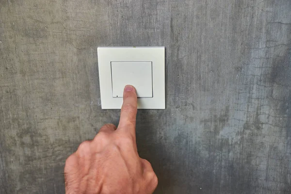 Man hand, to turn off the light, switch, front view