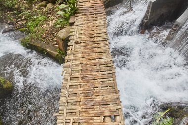 Dağ nehri üzerinde eski ahşap bir köprü