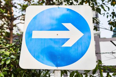 Mavi arka plan üzerinde beyaz ok lu yol işareti