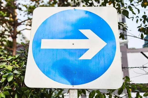 Verkeersbord met witte pijl op een blauwe achtergrond — Stockfoto