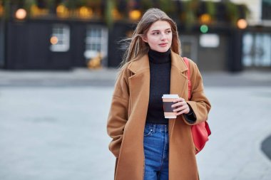 Şehir sokaklarında kahve içen şık bir kadın. 