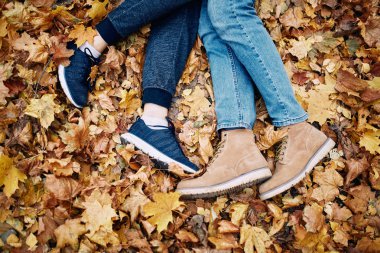 Parkta dinlenen bir erkek ve bir kızın bacakları