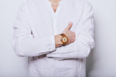 Elinde saat olan zarif beyaz gömlekli bir adam.