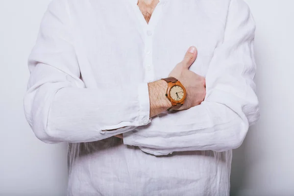 Un uomo in un'elegante camicia bianca con un orologio sulla mano — Foto Stock