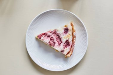 Beyaz bir tabaktabakta bir dilim çilekli turta