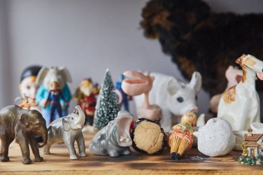 Masanın üstünde oyuncaklar ve heykelcikler var. Oyuncak toplama