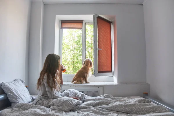 Young girl drinks tea in bed — Stock Photo, Image