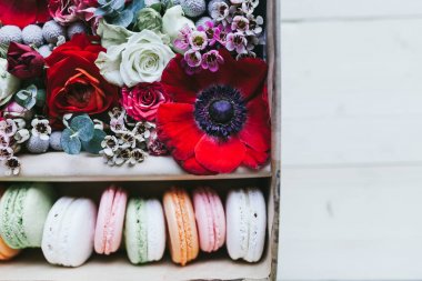 Çiçeklerle dolu bir hediye kutusunda renkli el yapımı makaronlar