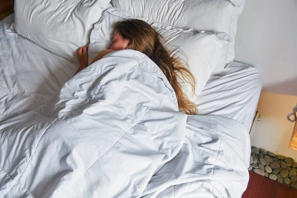 Young girl sleeping in a hotel bed — Stock Photo, Image