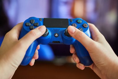 Kaliningrad, Rusya - 26 Temmuz 2019: Genç kız oyun konsolundan uzaktan kumandatutuyor. Bir kız video oyunları oynar.