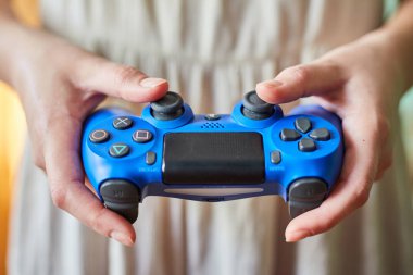 Kaliningrad, Rusya - 26 Temmuz 2019: Genç kız oyun konsolundan uzaktan kumandatutuyor. Bir kız video oyunları oynar.