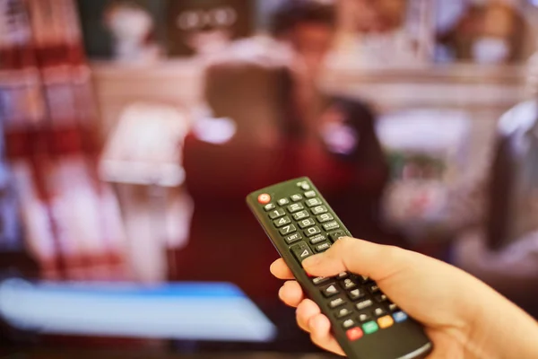 Young girl watching tv and holding a remote control from tv — Stock Photo, Image