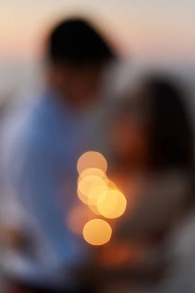 Σιλουέτα ενός νεαρού ζευγαριού που φιλάει στην παραλία το ηλιοβασίλεμα. Θαμπό φόντο. — Φωτογραφία Αρχείου