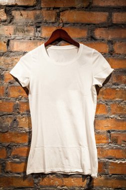Beyaz boş t-shirt kırmızı tuğla duvara asılı