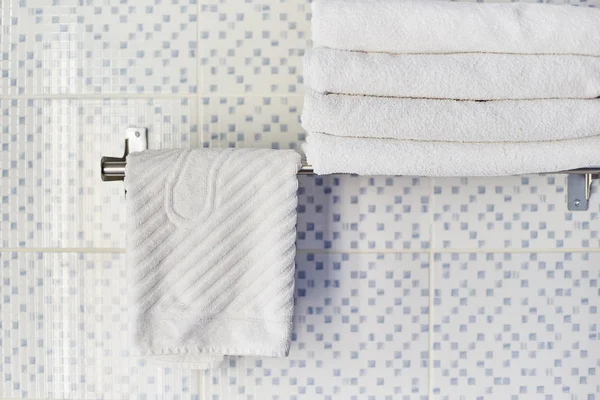 Una pila de toallas blancas limpias en una habitación de hotel. Toallas blancas se encuentran en un estante en el baño del hotel . —  Fotos de Stock