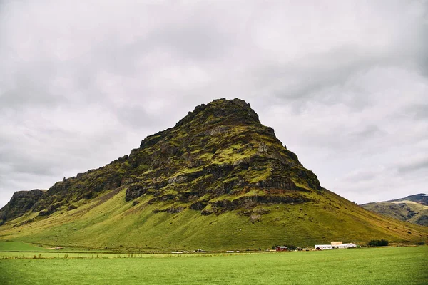 Vulkaniska berg på Island. Gård i området nära bergen. — Stockfoto