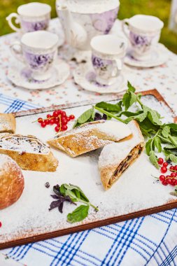Pudra şekeri serpilir bir tahta üzerinde Elma strudel ve elma