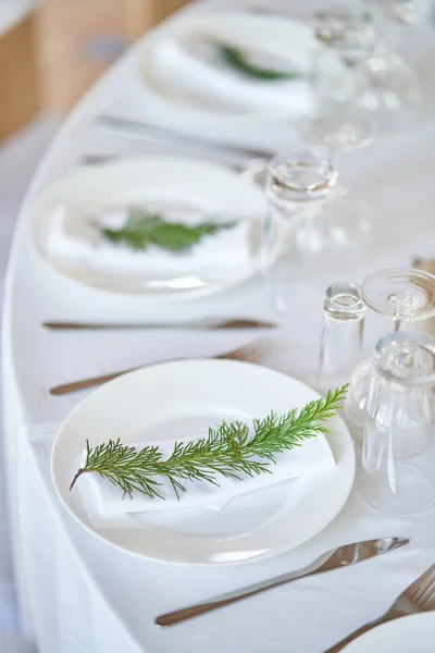 Wedding decorations. White plates on a white tablecloth. Natural style wedding