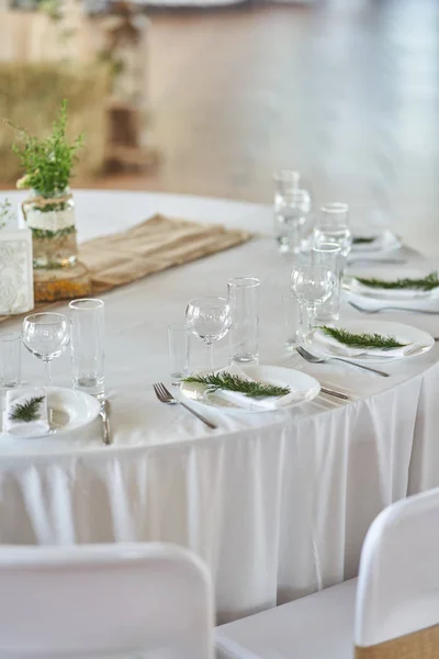 Wedding decorations. White plates on a white tablecloth. Natural style wedding