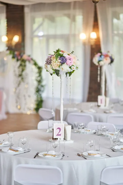 Plates with glasses on a table with a white tablecloth — Stock Photo, Image