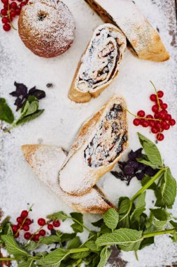 Pudra şekeri serpilir bir tahta üzerinde Elma strudel ve elma