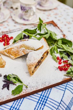 Pudra şekeri serpilir bir tahta üzerinde Elma strudel ve elma