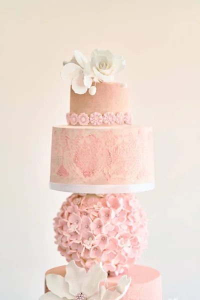 Big layered cake show. Pink cake with white roses