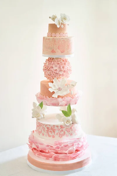 Big layered cake show. Pink cake with white roses