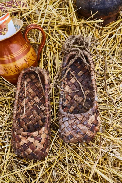 土産物市場のわらの上にバストシューズ。ロシアの伝統的な靴 — ストック写真