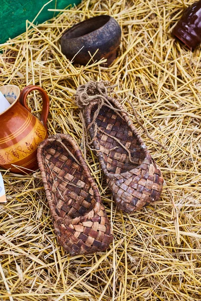土産物市場のわらの上にバストシューズ。ロシアの伝統的な靴 — ストック写真